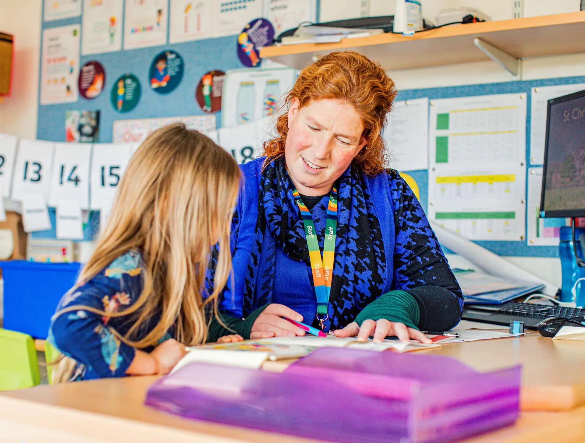 Junior School teacher at St Chris helping a pupil in class